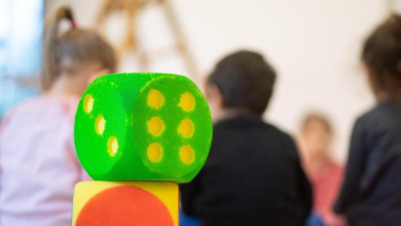 Zwei Würfel stehen in einer Kindertagesstätte vor Kindern, die in einem Kreis sitzen. Foto: Sebastian Gollnow/Archivbild Zwei Würfel stehen in einer Kindertagesstätte vor Kindern, die in einem Kreis sitzen. Foto: Sebastian Gollnow/Archivbild