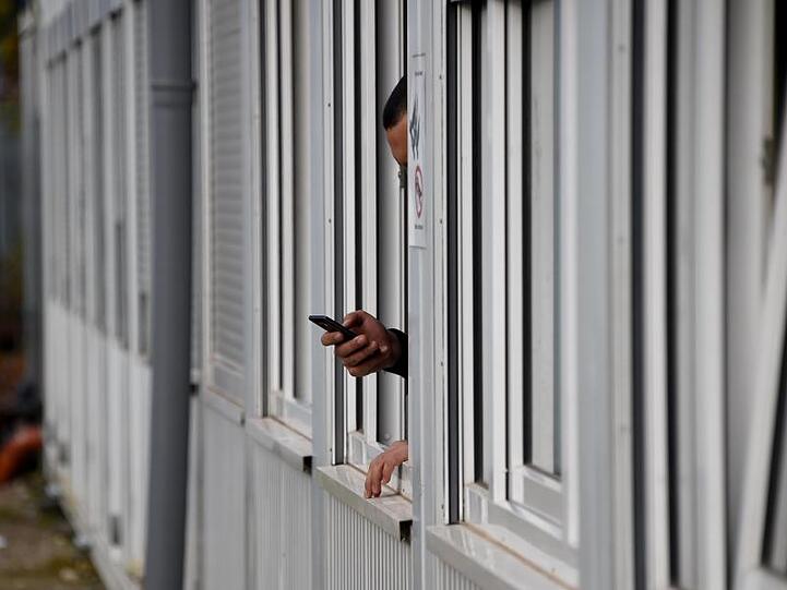 Ein Mann telefoniert in einem Wohncontainer auf dem Gelände der Erstaufnahmeeinrichtung für Flüchtlinge in Neumünster.