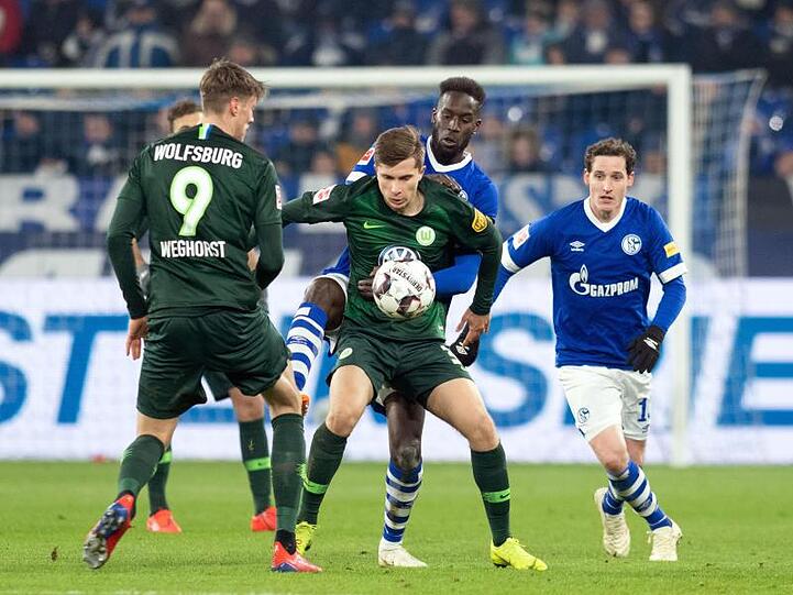 Kampf um den Ball zwischen Schalkes Salif Sane (M hinten) und Wolfsburgs Elvis Rexhbecaj (M).