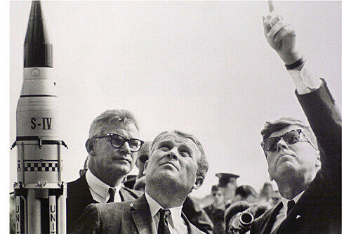 Wernher von Braun (Mitte) und Amerikas Präsident John F. Kennedy (rechts) beobachten den Start einer Rakete.