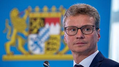 Bernd Sibler (CSU) steht neben einem Mikrofon. Hinter ihm ist das bayerische Landeswappen zu sehen. Foto: Peter Kneffel/dpa-pool/dpa/Archivbild