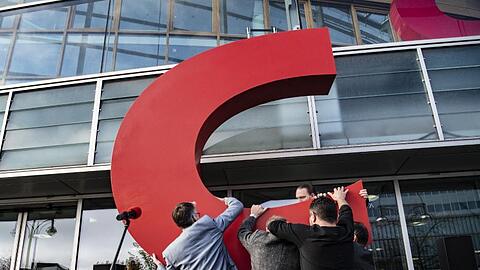 Mitarbeiter nehmen das C vor der Parteizentrale entgegen.