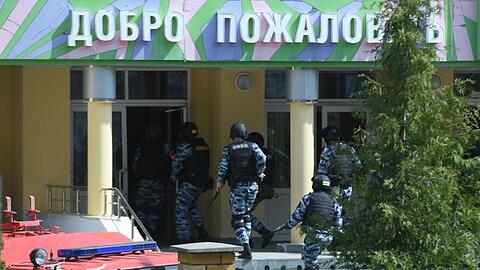 Rettungswagen und Polizeifahrzeuge mit Blaulicht und Sirene: der Tatort in der russischen Stadt Kasan nach dem tödlichen Angriff.