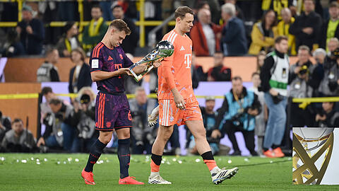 Joshua Kimmich (l., mit Manuel Neuer) begutachtet den Franz-Beckenbauer-Supercup. Der Sieg &uuml;ber Dortmund freut ihn, die "Art und Weise" des Triumphes aber weniger.