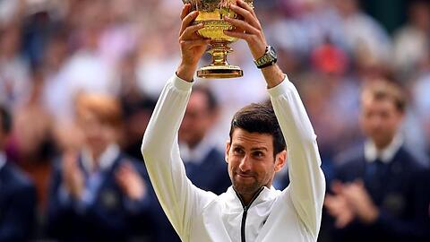 Novak Djokovic hält die Wimbledon-Trophäe zum fünften Mal in seinen Händen.