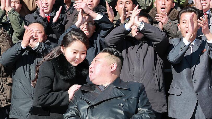 Kim Jong Un und seine Tochter, die laut Angaben mit Wissenschaftlern und Arbeitern für ein Foto zusammen stehen.