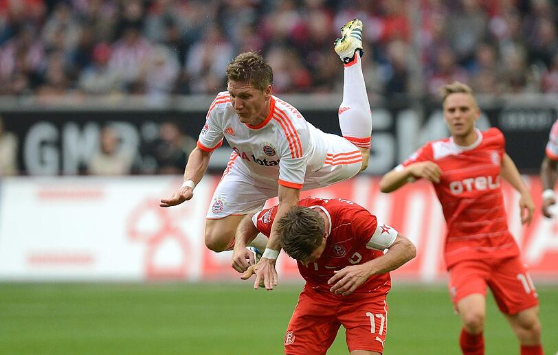 Beim 5:0 im Hinspiel in Düsseldorf ist Bastian Schweinsteiger obenauf, Düsseldorfs Andreas Lambertz macht sich klein.
