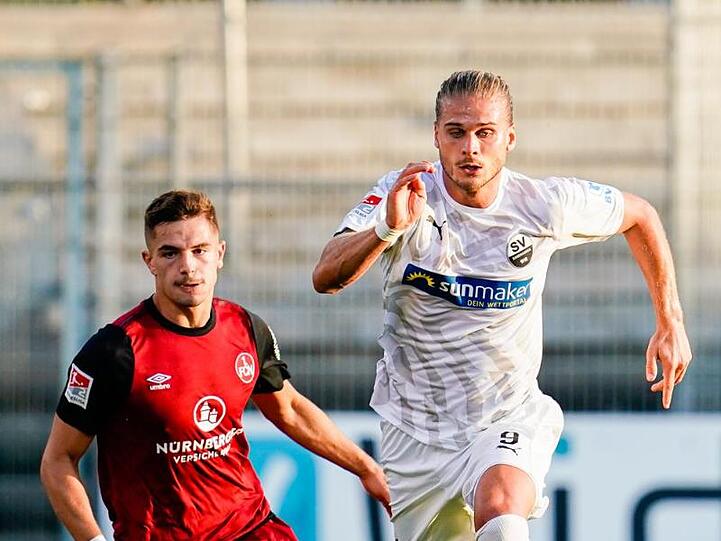 Nürnbergs Nikola Dovedan (l.) und Sandhausens Rurik Gislason kämpfen um den Ball. Foto: Uwe Anspach