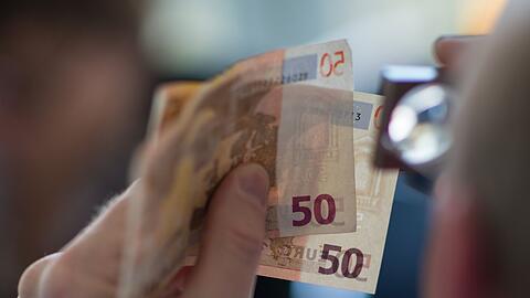 Prüfender Blick: Ein Ladenmitarbeiter bemerkte das Falschgeld.