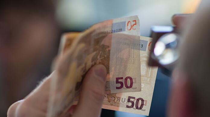 Prüfender Blick: Ein Ladenmitarbeiter bemerkte das Falschgeld.