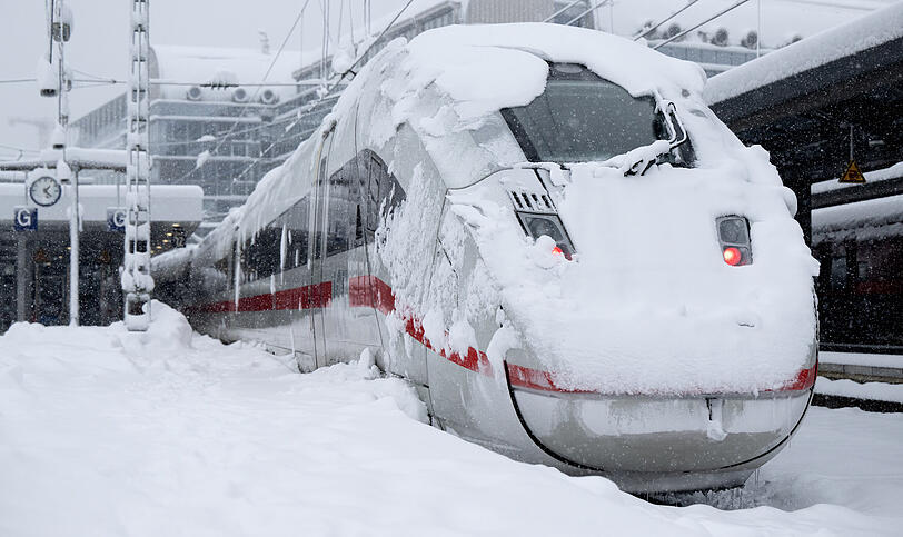 Ein ICE der Deutschen Bahn (DB) steht auf einem verschneiten Gleis am Hauptbahnhof.