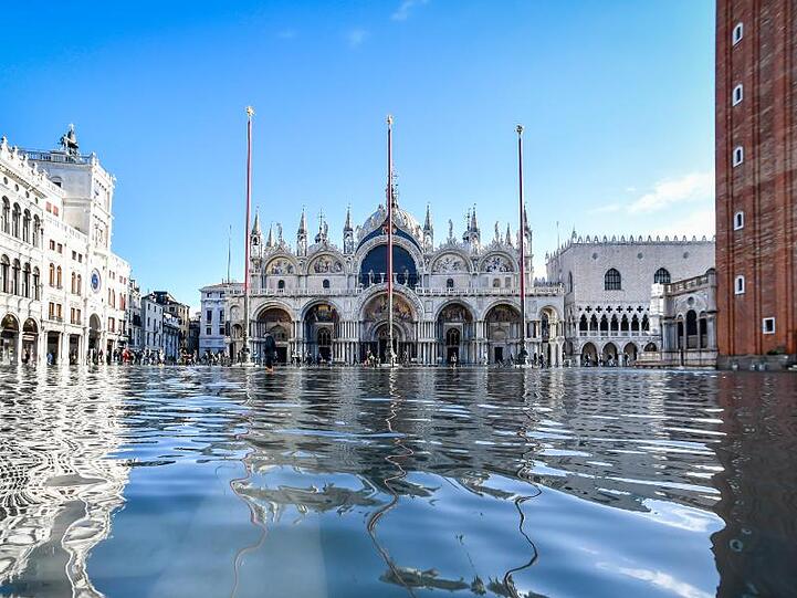 Der Dogenpalast spiegelt sich im Hochwasser auf dem Markusplatz.