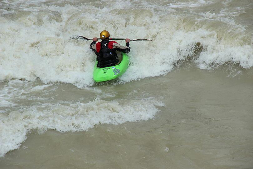 Hochwasser für die einen, perfekte Wellen für die anderen. Waghalsig tummeln sich Sportler in der Isar.