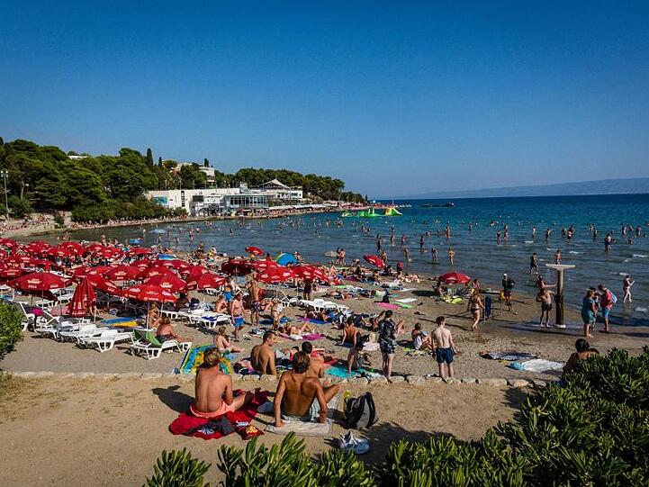 Badegäste sonnen sich am Strand Bacvice. Wegen der gestiegenen Zahl von Corona-Neuinfektionen hat das Auswärtige Amt eine Reisewarnung für Teile des Urlaubslands Kroatien ausgesprochen.