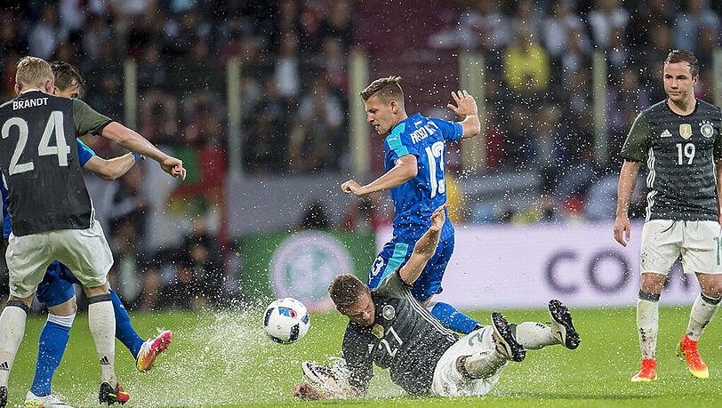 Ausgerutscht in der "Wasserschlacht" von Augsburg: Joshua Kimmich (Deutschland) im Zweikampf gegen Patrik Hrosovsky (Slowakei). Ausgerutscht in der "Wasserschlacht" von Augsburg: Joshua Kimmich (Deutschland) im Zweikampf gegen Patrik Hrosovsky (Slowakei).