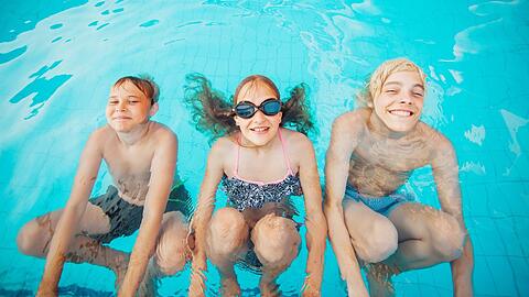 Drei Kinder vergnügen sich in einem Pool. Im Starnberger Seebad haben sich im letzten Jahr ganze Jugendtreffs gebildet. (Symbolbild)