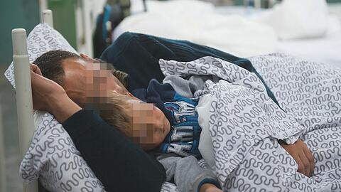Ein Flüchtling teilt sich mit seinem Sohn ein Bett in der Bayernkaserne. Seit vielen Wochen ist dort der Platz knapp.