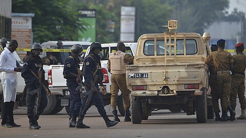 Polizisten und Soldaten stehen in Ouagadougou an einer Straßensperre. Bei einem nächtlichen Angriff auf ein Restaurant Menschen getötet und verletzt. Foto: Ahmed Ouoba