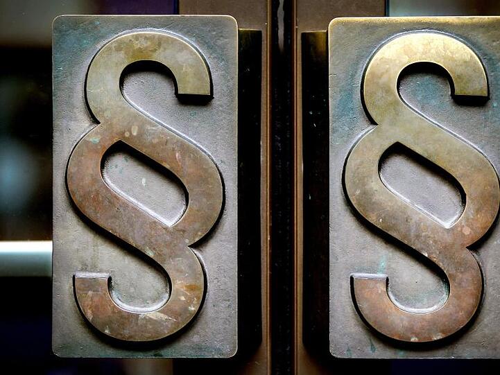 Paragrafen-Symbole sind an Türgriffen angebracht. Foto: Oliver Berg/dpa/Archivbild