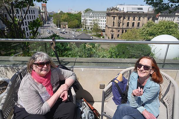 Die Freundinnen Marianne und Carola genie&szlig;en die Aussicht beim Oberpollinger bei einem gem&uuml;tlichen Ratsch. Der Trubel unten am Stachus ist ganz weit weg.