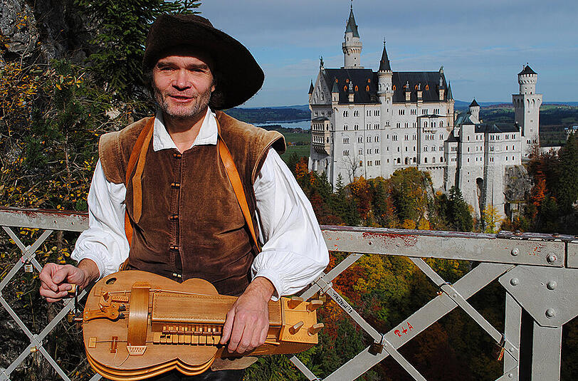 Musiker Kay Reinhardt auf der Marienbrücke vor dem Schloss Neuschwanstein. Endlich darf er dort wieder Drehleier spielen.