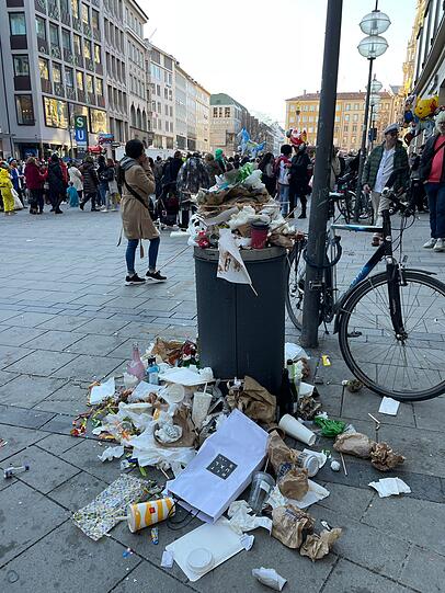 Faschingsdienstag am Marienplatz: Der Mülleimer quillt bereits mehr als über.