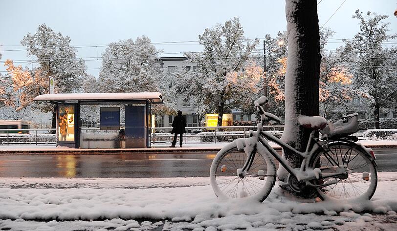 Warten auf die Tram: Radlfahren ist bei diesem Schneewetter in München nicht jedermanns Sache.