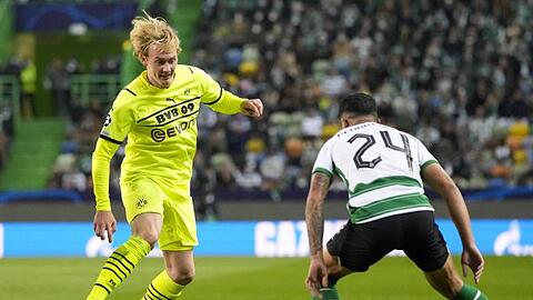 Dortmunds Julian Brandt fintiert, um an Sportings Pedro Porro (r) vorbeizukommen.