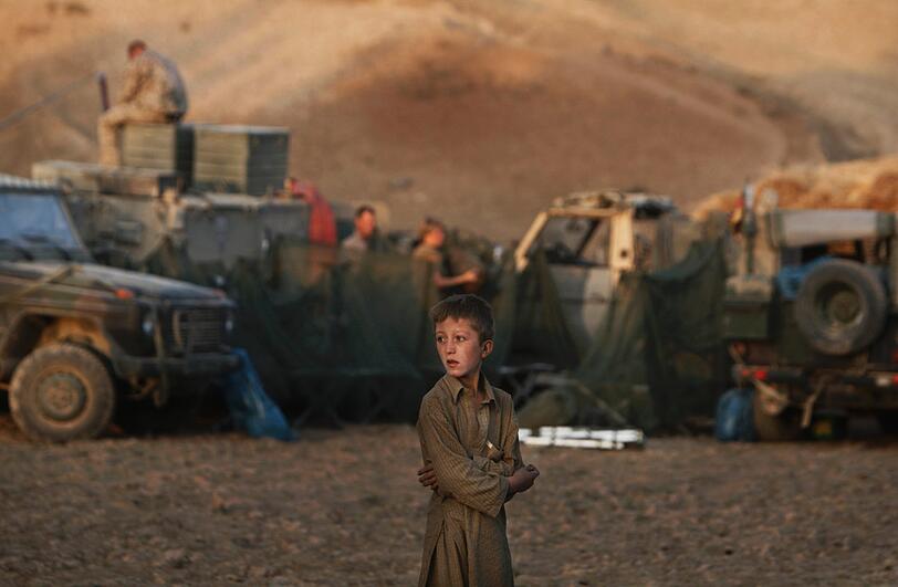 Ein Junge beobachtet die ISAF-Truppen in Afghanisten beim Errichten eines Nachtlagers.