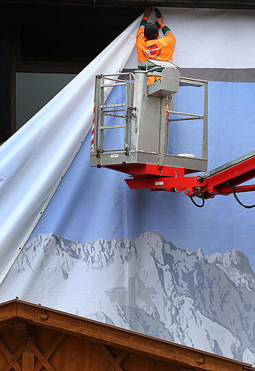 Das Alpenpanorama-Banner am Kurhaus in Garmisch wird abgehängt.