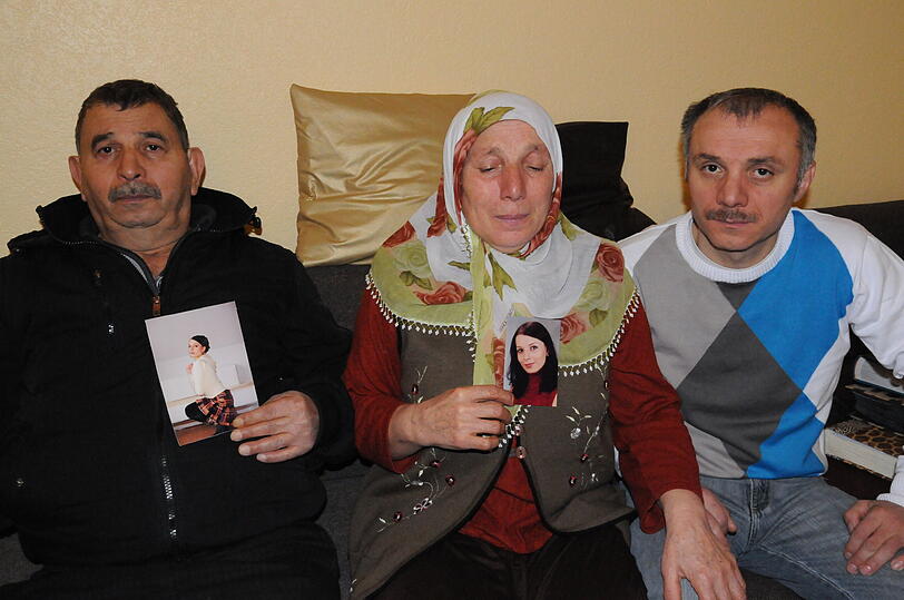Ahmet P., seine Frau Fatma und Sohn Remzi halten Fotos von Lara in der Hand.
