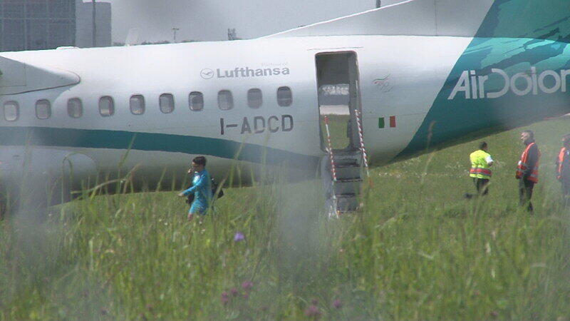 Mitarbeiter des Flughafens in München betrachten die Maschine der italienischen Fluggesellschaft, die am Donnerstag auf dem Münchner Flughafen notlanden musste. Das Flugzeug mit 62 Menschen an Bord hatte kurz nach dem Start in Richtung Venedig umdrehen müssen, weil sich Rauch in der Kabine entwickelt hatte. Bei der Landung wurden fünf Personen leicht verletzt, die Maschine kam neben der Landebahn zum Stehen.