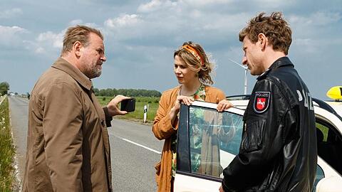 Kommissar Brockhorst (Felix Vörtler, l) und Henk Cassens (Maxim Mehmet, r) stoppen Susanne Bock (Katrin Röver) auf der Straße.