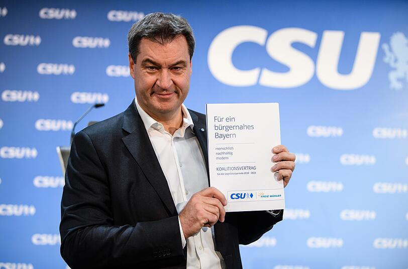 Markus Söder (CSU), Ministerpräsident von Bayern, zeigt auf einer Pressekonferenz nach einer Sitzung des CSU-Vorstands und der CSU-Landtagsfraktion den neuen Koalitionsvertrag für Bayern.