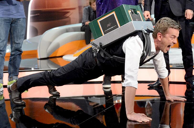 Und da ist es: Das Spaß-Bild des Abends. Markus Lanz stemmt sich und den Bierkasten tapfer und publikumswirksam hoch.