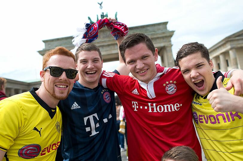 Immer gegeneinander - von wegen! Fans vom FC Bayern München und Borussia Dortmund feiern gemeinsam vor dem Brandenburger Tor.