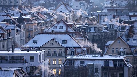 Qualm steigt aus den Schornsteinen und Abzügen an einem kalten Wintermorgen in der Leipziger Südvorstadt auf.