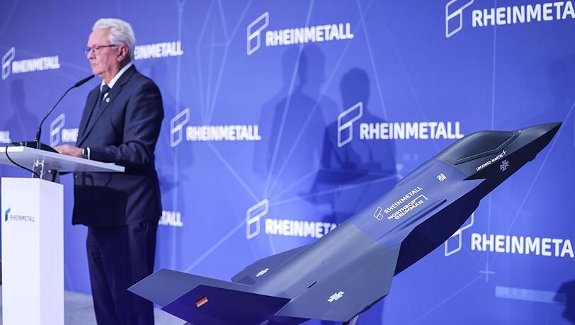 Ein Modell des F-35 auf der Bühne, auf der Konzernchef Papperger zu Mitarbeitern spricht.