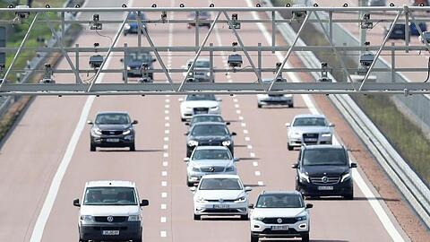 Autos fahren unter einer Mautbrücke auf der Autobahn A9 hindurch.