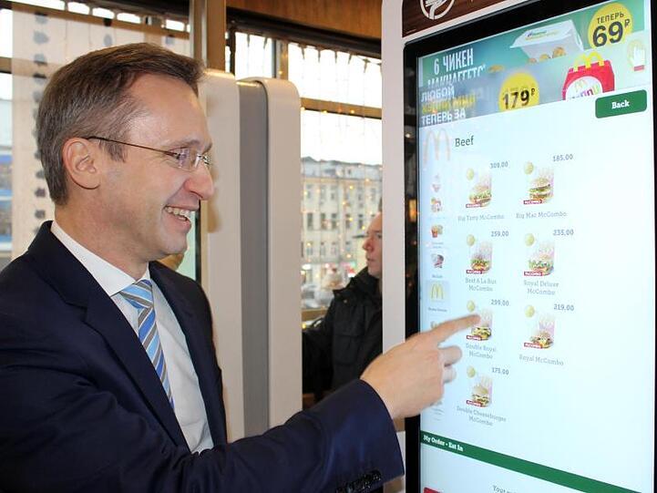 Der Chef von McDonald's in Russland, Marc Carena, zeigt auf einen Bestellautomaten in einer Filiale in Moskau.