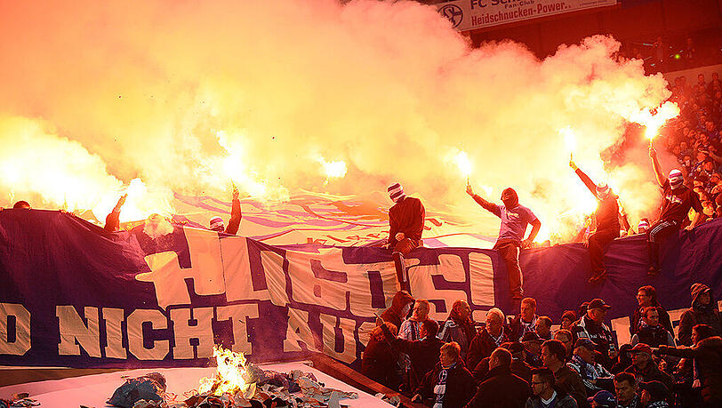 Schalker Anhänger zünden Pyrotechnik auf der Tribüne ab. Jetzt muss ein 25-Jähriger Fan für 18 Monate ins Gefängnis. Schalker Anhänger zünden Pyrotechnik auf der Tribüne ab. Jetzt muss ein 25-Jähriger Fan für 18 Monate ins Gefängnis.