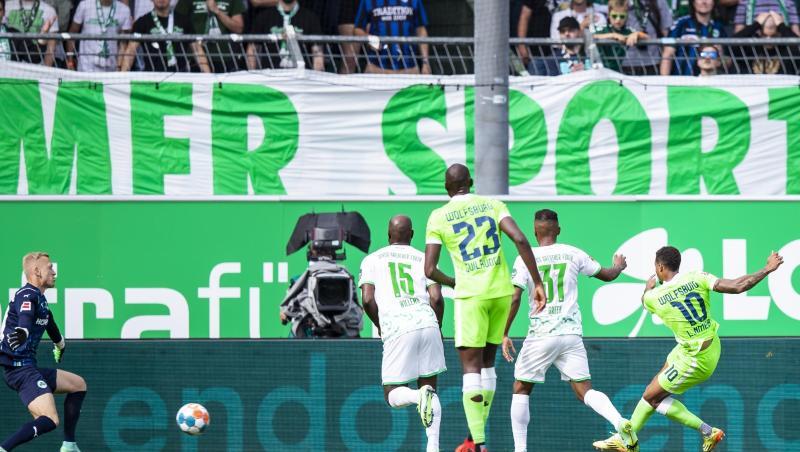 Wolfsburgs Lukas Nmecha (r) schießt den Ball zur Führung ins Tor.