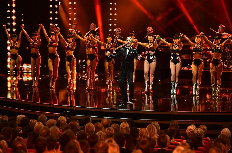 Robbie Williams steht bei der 68. Verleihung des Medienpreises Bambi auf der Bühne - im Hintergrund: Sehr viel Bein!