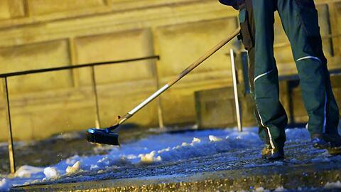 Ein Mann r&auml;umt Schnee vor der Alten Pinakothek in M&uuml;nchen. In der Nacht soll es wieder k&auml;lter werden, mit Schneefall bis in die Niederungen.