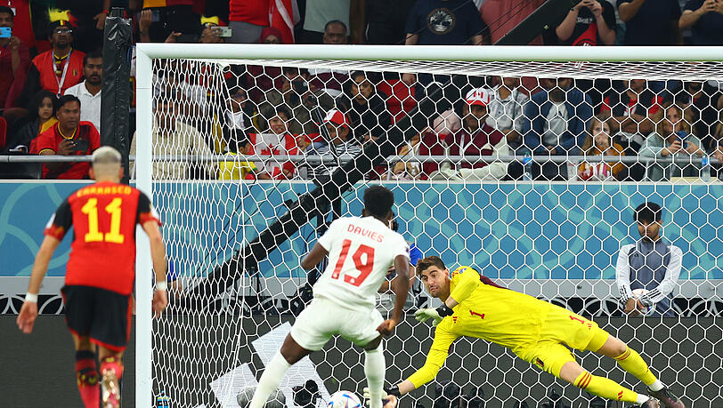 Belgiens Torwart Thibaut Courtois (hinten) hält den Strafstoß von Kanadas Alphonso Davies. Belgiens Torwart Thibaut Courtois (hinten) hält den Strafstoß von Kanadas Alphonso Davies.