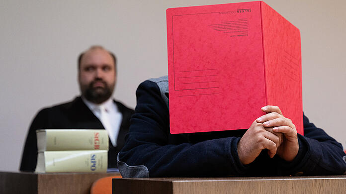 Der wegen Vergewaltigung angeklagte Mann (r) sitzt vor seinem Anwalt Markus Otto im Landgericht im Gerichtssaal.