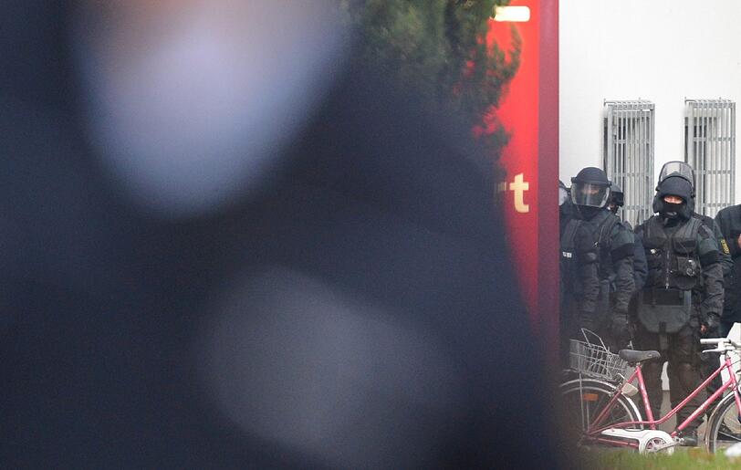 Mit erhobenen Händen kommt ein Mann auf die SEK-Beamten zu, im Hintergrund lauern Heckenschützen der Polizei. Die Beamten nehmen den Mann fest, es ist aber nicht der Täter, der sich in einem Imbiss in Freiburg veschanzt hat.