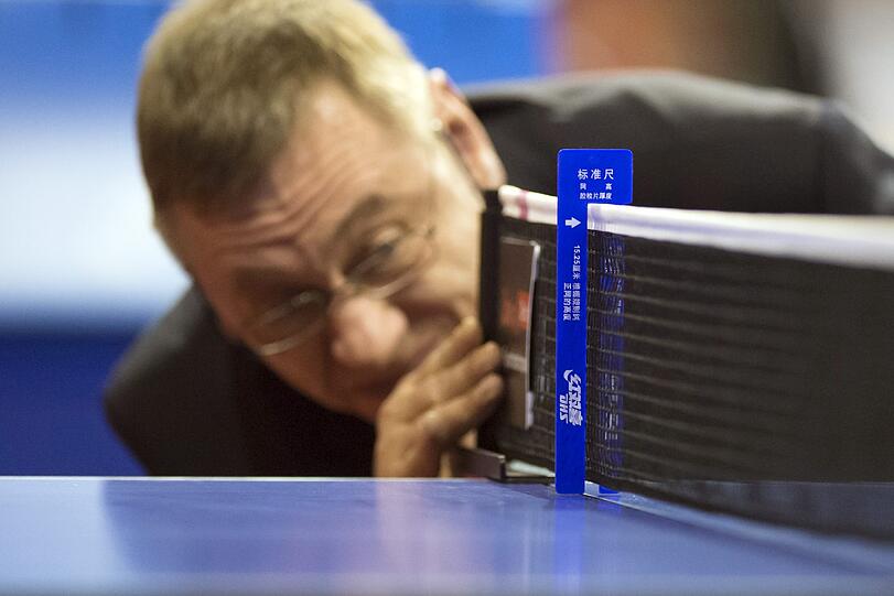 Millimeterarbeit: Bei den German Open im Tischtennis in Berlin überprüft Schiedsrichter Peter Logsch vor Spielbeginn die Höhe des Netzes.