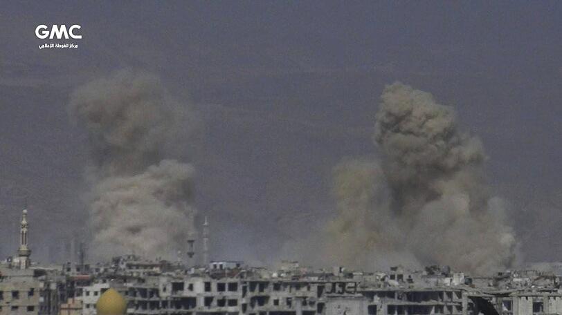 Das von der regierungskritischen Aktivistengruppe Ghouta Media Center (GMC) zur Verfügung gestellte Foto und durch Abgleich mit AP-Berichterstattung authentifizierte Foto zeigt Rauch, der nach einem Angriff durch die syrische Luftwaffe aufsteigt.