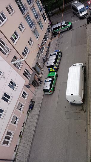 Einsatzfahrzeuge der Polizei stehen in einer Seitenstraße des Gerichtsgebäudes.